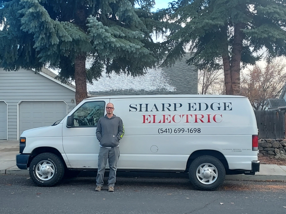 Electrician in front of company van